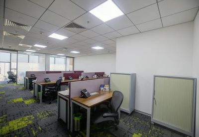 Open-plan office space with multiple rows of workstations and ergonomic task chairs.