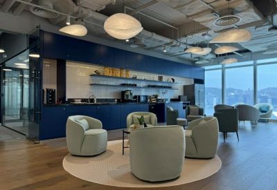Stylish lounge area with blue cabinetry, curved armchairs, and orb pendant lights.