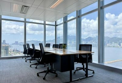 Executive corner office with a wooden desk and expansive floor-to-ceiling windows.