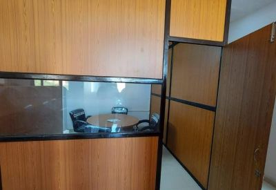 Small private office suite with wooden partitions and glass viewing panel.
