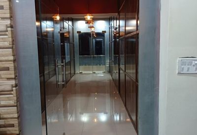 Bright hallway with glass doors and polished tiled flooring.
