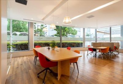 Spacious coworking area with warm wooden floors and large windows.