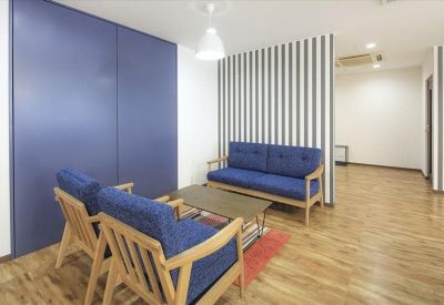 Comfortable lounge area with blue sofas and a feature striped wall.