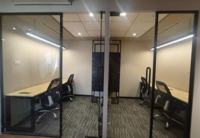 Private glass-enclosed office suites with workstations and ergonomic chairs.