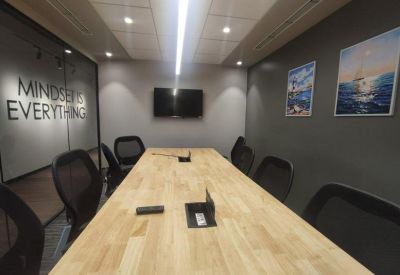 Modern conference room with a long wooden table and motivational wall art.