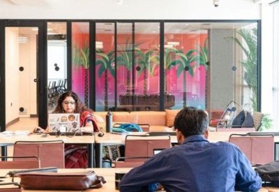 Reception area or lobby with glass partitions and vibrant palm tree wall art.