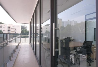 Private office space viewed through glass doors with a sleek balcony and city views.