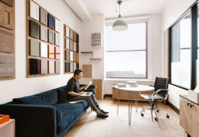 Private office suite with a dark velvet sofa and wall-mounted material samples.
