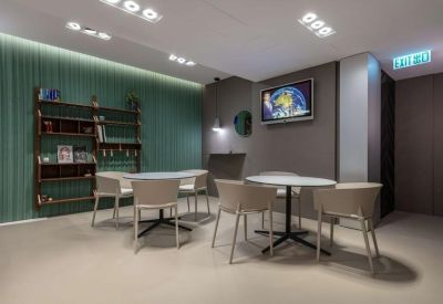 Minimalist meeting room with white chairs, round tables, and a wall-mounted TV.