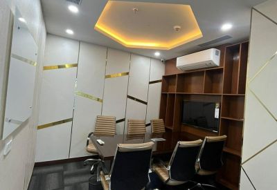 Private meeting room with a central table, leather chairs, and a geometric light fixture.