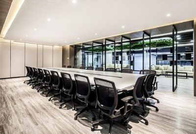 Large conference room with a long white table and black ergonomic chairs.