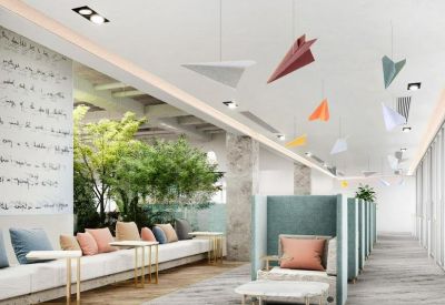 Modern coworking space with high-back privacy booths and decorative paper airplane ceiling art.