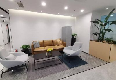 Inviting breakout space with comfortable lounge seating, a coffee table, and large indoor plants.