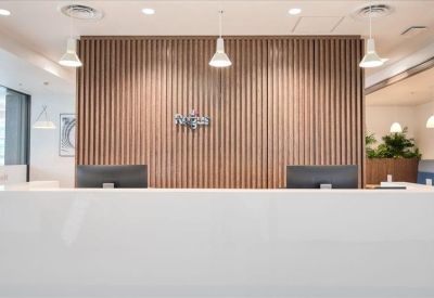 Sleek white reception desk with a vertical wood-slat feature wall.