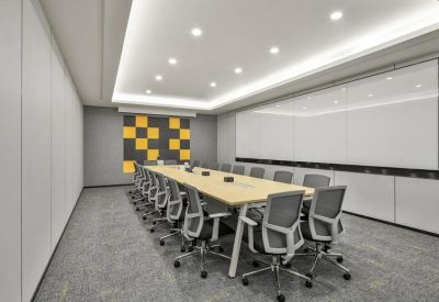 Modern boardroom with a light wood table and a yellow and grey geometric feature wall.