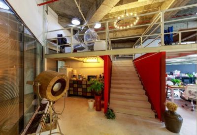 Industrial-style reception lobby with a wooden staircase and mezzanine level.