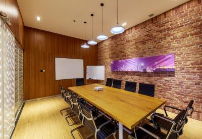Modern meeting room with a large wooden table, brick accent wall, and hanging pendant lights.