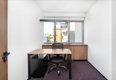 Private office suite with a wooden desk and large window.