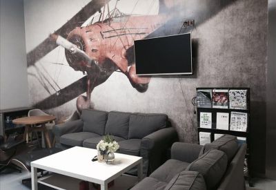 Modern lounge area with grey sofas, a coffee table, and a large vintage aviation mural.