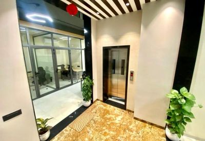 Elevator lobby featuring an accent ceiling with stripes and indoor potted plants.