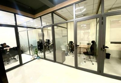 Private office suite with glass partitions and ergonomic black chairs.