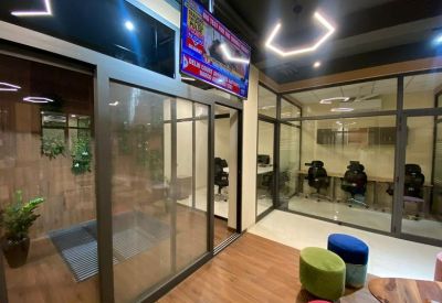 Glass meeting room containing a wooden table and ergonomic seating.