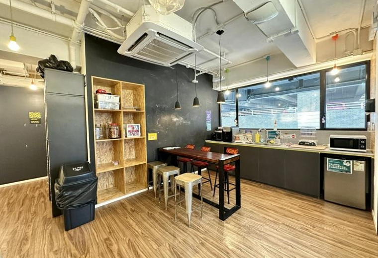 Spacious communal kitchen and dining area at 118 Wai Yip Street with wooden floors and a chalkboard wall.