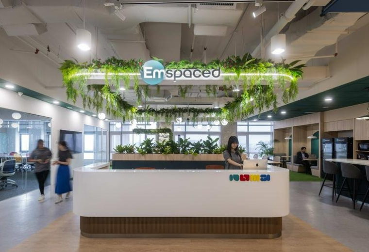 Modern reception area at NU Tower 1 featuring a white desk and hanging plants.