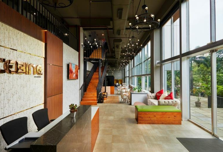 Bright lobby at Park Site Road, HMPL Surya Nagar, Mumbai with wood reception desk and floor-to-ceiling windows.