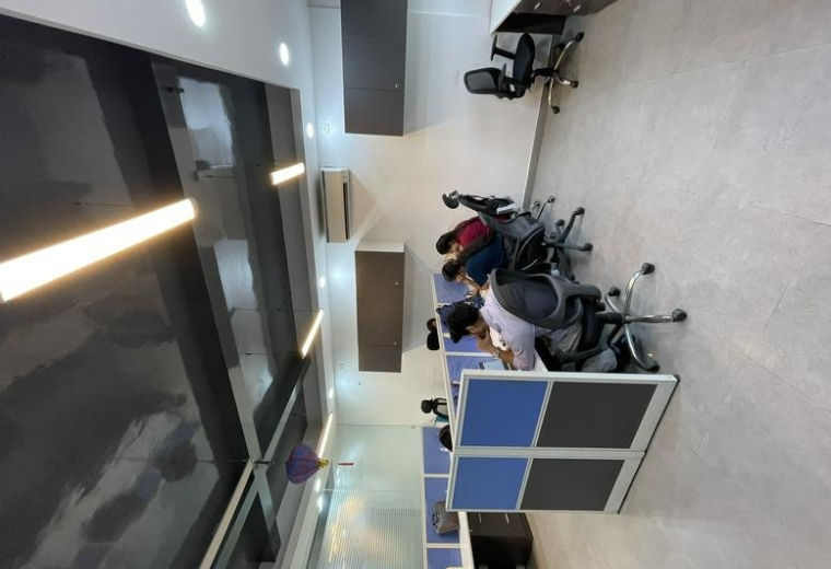 Spacious open-plan workspace at Indraprakash Building with modern workstations and sleek ceiling lighting.
