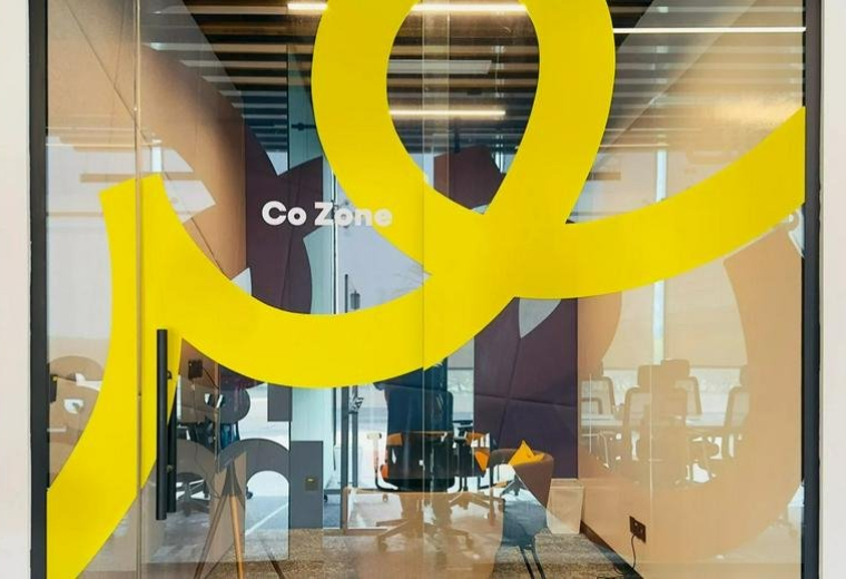 Entrance to the Co Zone at 2661, الامير سلطان showing glass walls with yellow graphics.
