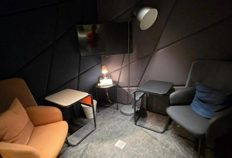 Dimly lit private acoustic booth at Al Andalus Road, Souls Center featuring armchairs and a wall-mounted TV.
