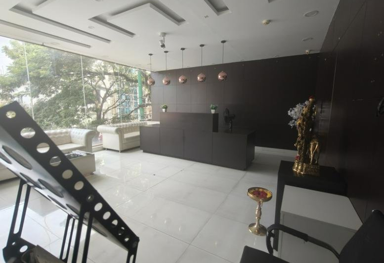 Spacious reception area of cubiqo featuring a dark wood desk and designer pendant lighting.