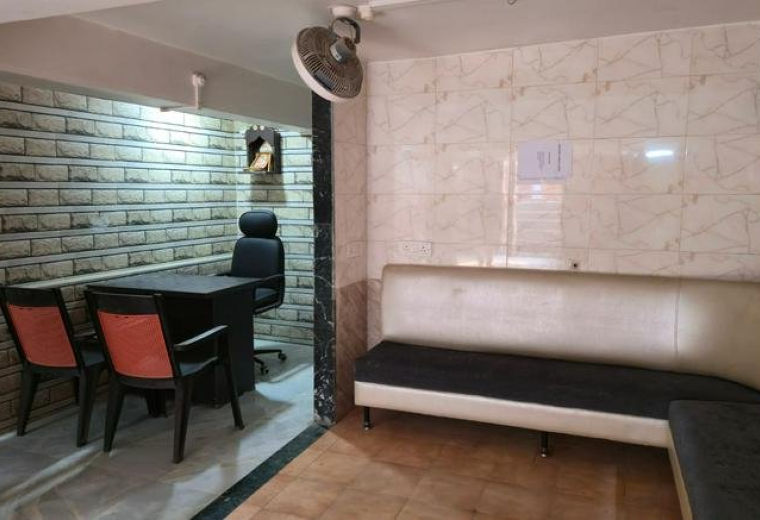 Spacious waiting area featuring a long L-shaped banquette sofa and an adjacent private office space.