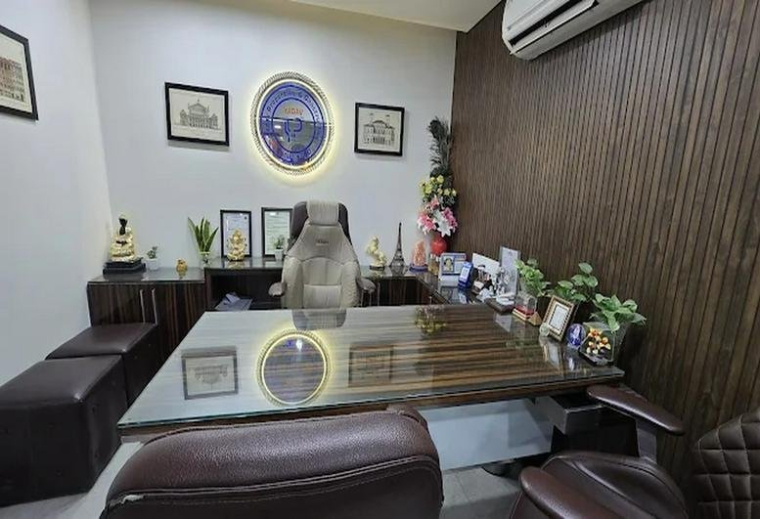 Private office at Lower Ground Floor, H. No. 69, featuring a wood-paneled wall, executive desk, and professional decor.