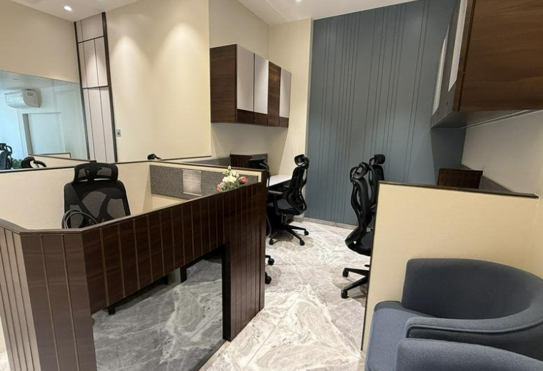 Reception area at Mahinder Chambers with dark wood paneling and blue armchairs.