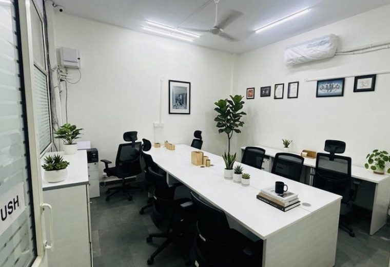 Spacious Rama Road, Kirti Nagar office with long white desks, ergonomic chairs, and indoor plants.