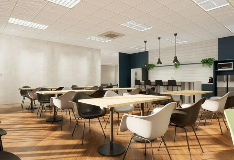 Spacious cafeteria at 9F Johndorf Tower featuring modern dining tables and warm wooden flooring.