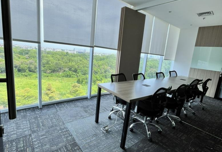 Professional meeting room with a large wooden table and views of green landscape.