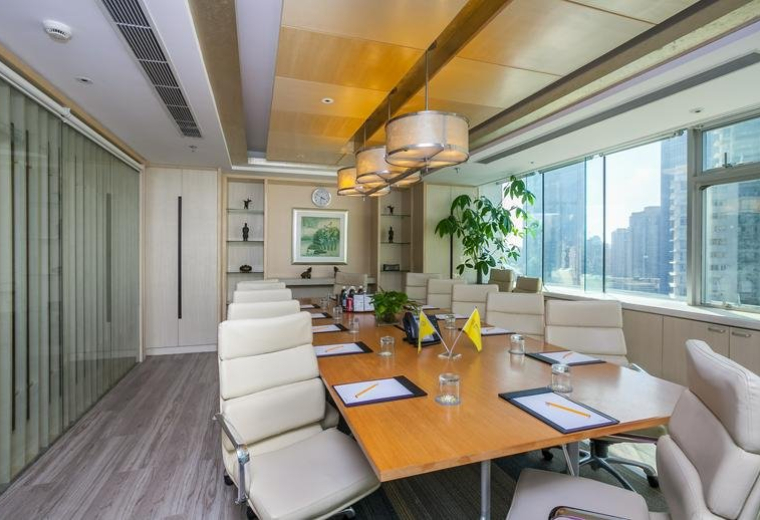 Professional meeting room with a large wood table, white leather chairs, and city views through large windows.