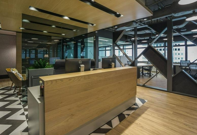 Modern reception area at Singapore Land Tower, 50 Raffles Place with wood paneling and chevron flooring.