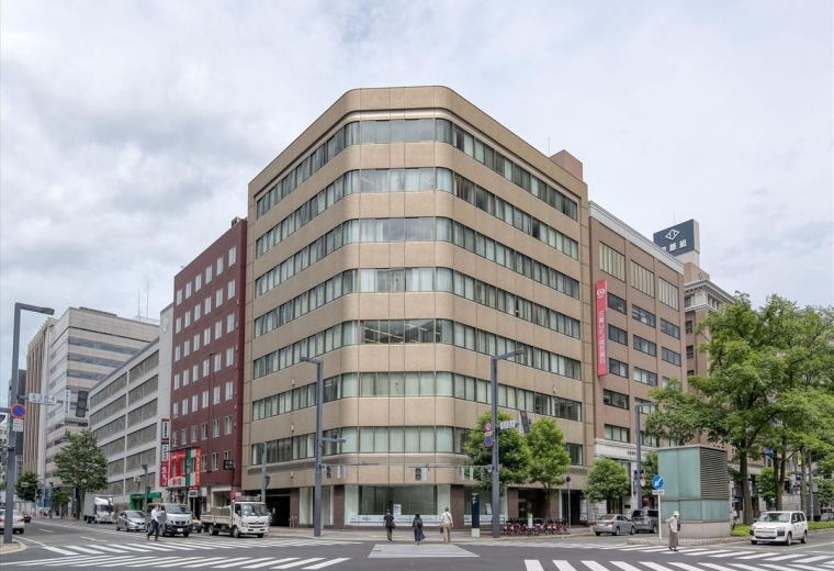 Exterior view of the multi-story MMS Sapporo Ekimae bldg at a city intersection.