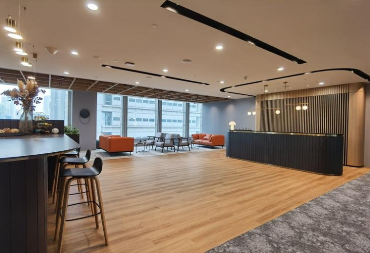 Warm, light-filled reception area at Smartworks Great Eastern Centre with wood floors and a dark marble front desk.