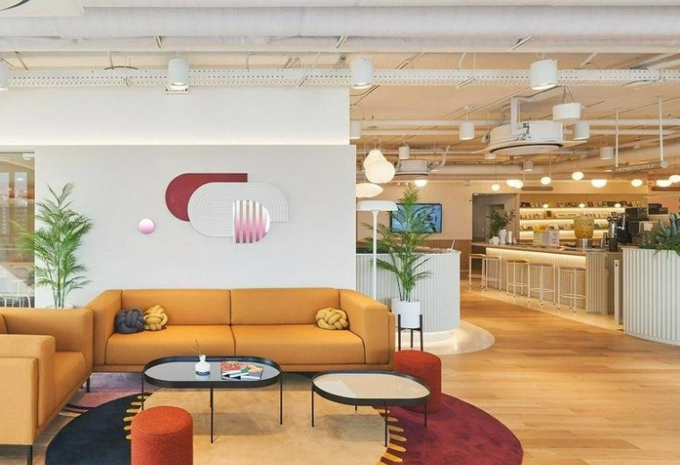 Spacious communal lounge at K-Square, 10 Gangnamdae-ro 94-gil, featuring a mustard sofa and colorful circular rugs.