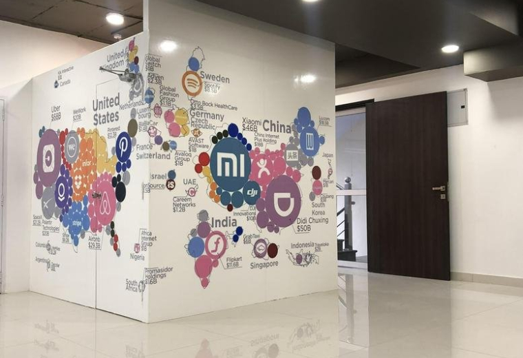 Sleek reception area at 147 Mahaveer Nagar with an orange front desk and wood-paneled feature wall.