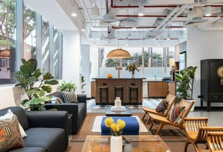 Modern lounge area featuring comfortable sofas, wooden armchairs, and a stylish bar counter.