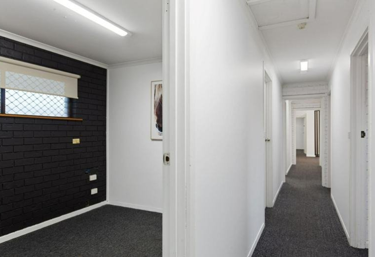 Brightly lit white corridor leading to several private office suites at 44 Osborne Road, North Haven.
