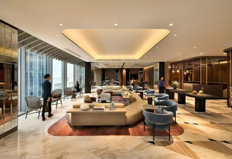 Main lounge area at 63 Robinson Road featuring curved sofas, designer armchairs, and a bright recessed ceiling.