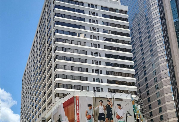 Exterior view of the tall, white-facade Leighton Centre building with street-level retail.