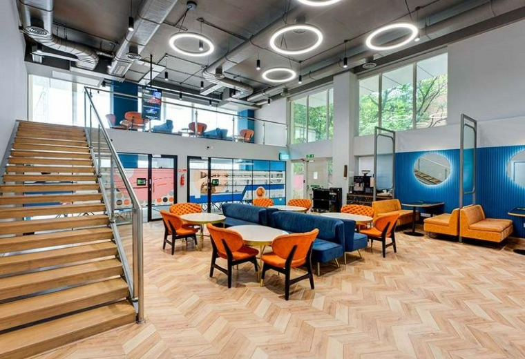 Spacious communal dining area at Bhairav Milestone with marble tables, wooden chairs, and globe pendant lighting.